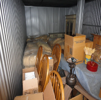 Storage locker filled with sofas and dining furniture.