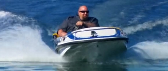 Ton Jones drives a miniboat on the water.