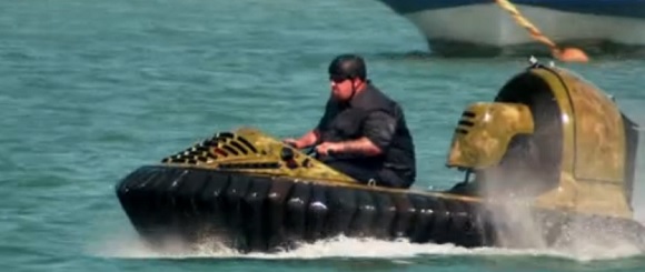 Ton Jones from Auction Hunters on hover craft on water.