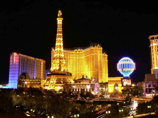 Paris Hotel with mini Eiffel Tower in Vegas at night.