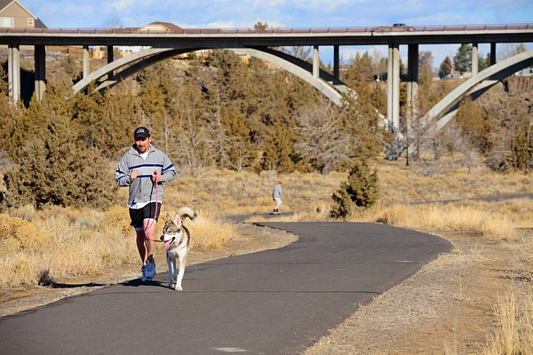 Man jogs with dog on Dry Canyon Trail.