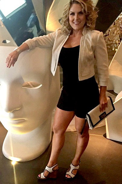 Casey Nezhoda stands next to chair shaped like a face.