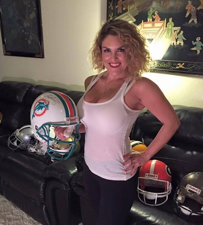 Casey Nezhoda holds up a football helmet.