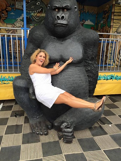 Casey Nezhoda sits on a fake ape`s lap.
