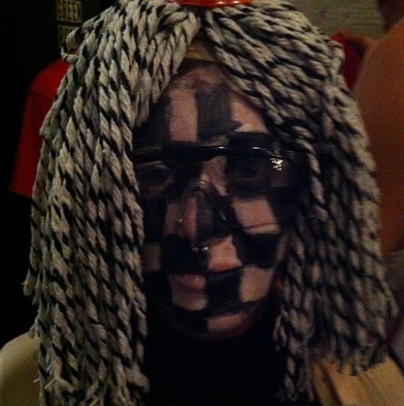 Courtney Wagner in checkered black make-up and mop head.